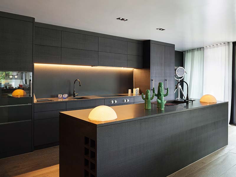 Modern kitchen with dark cabinetry and under-cabinet lighting